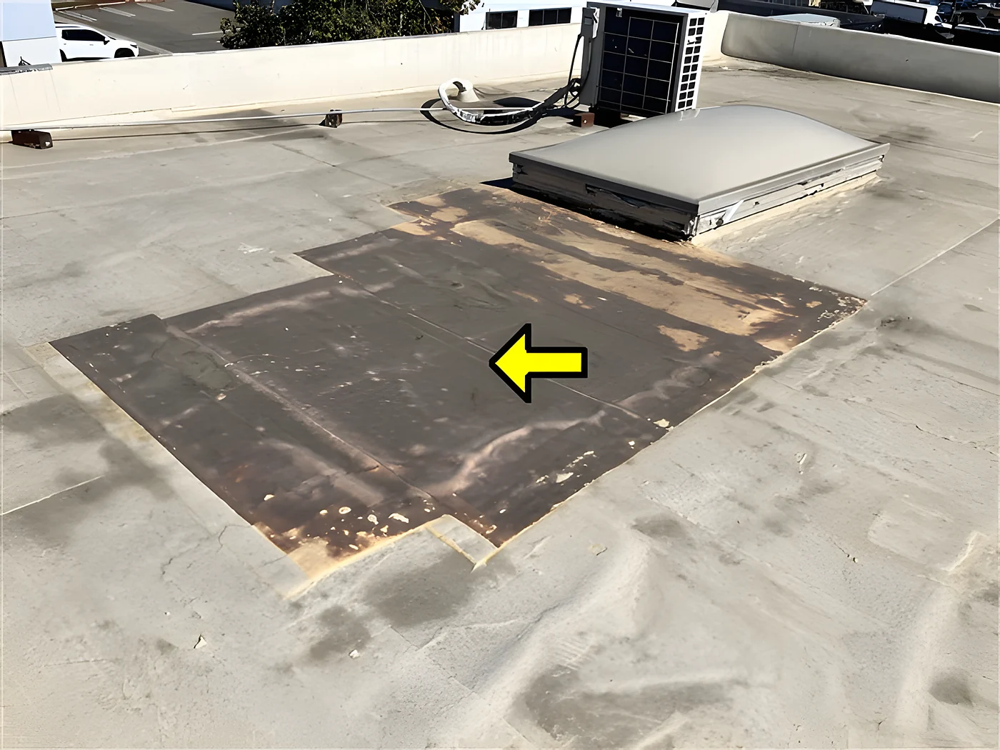 A previously repaired area of a commercial flat roof, flagged in the report as a capital item