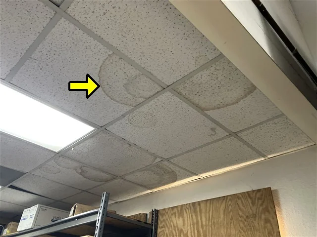 Moisture staining in the suspended ceiling of a tenant space, marked up in the report