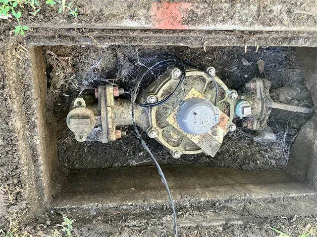 The water meter and backflow assembly in the street vault serving a commercial building