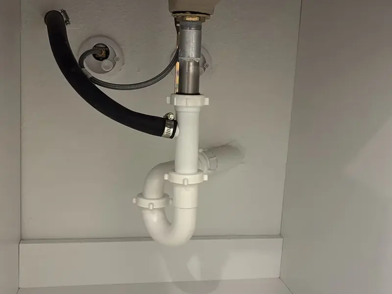 Under a sink: the P-trap, supply stop and drain line