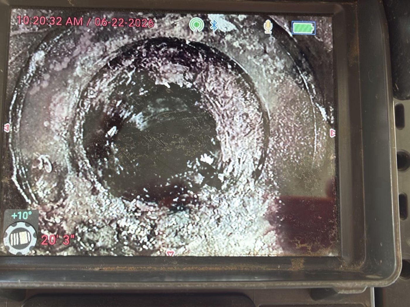 Sewer scope monitor screen displaying the inside of a residential drain pipe at 20 feet depth, showing pipe condition during camera inspection
