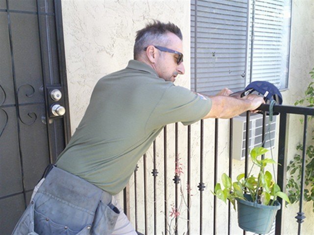 Inspector performing a manual load test on an iron balcony railing