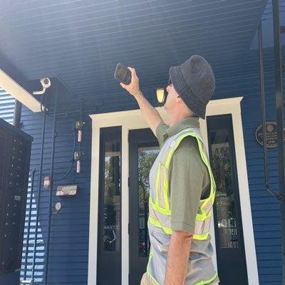 Inspector photographing a walkway ceiling during an inspection