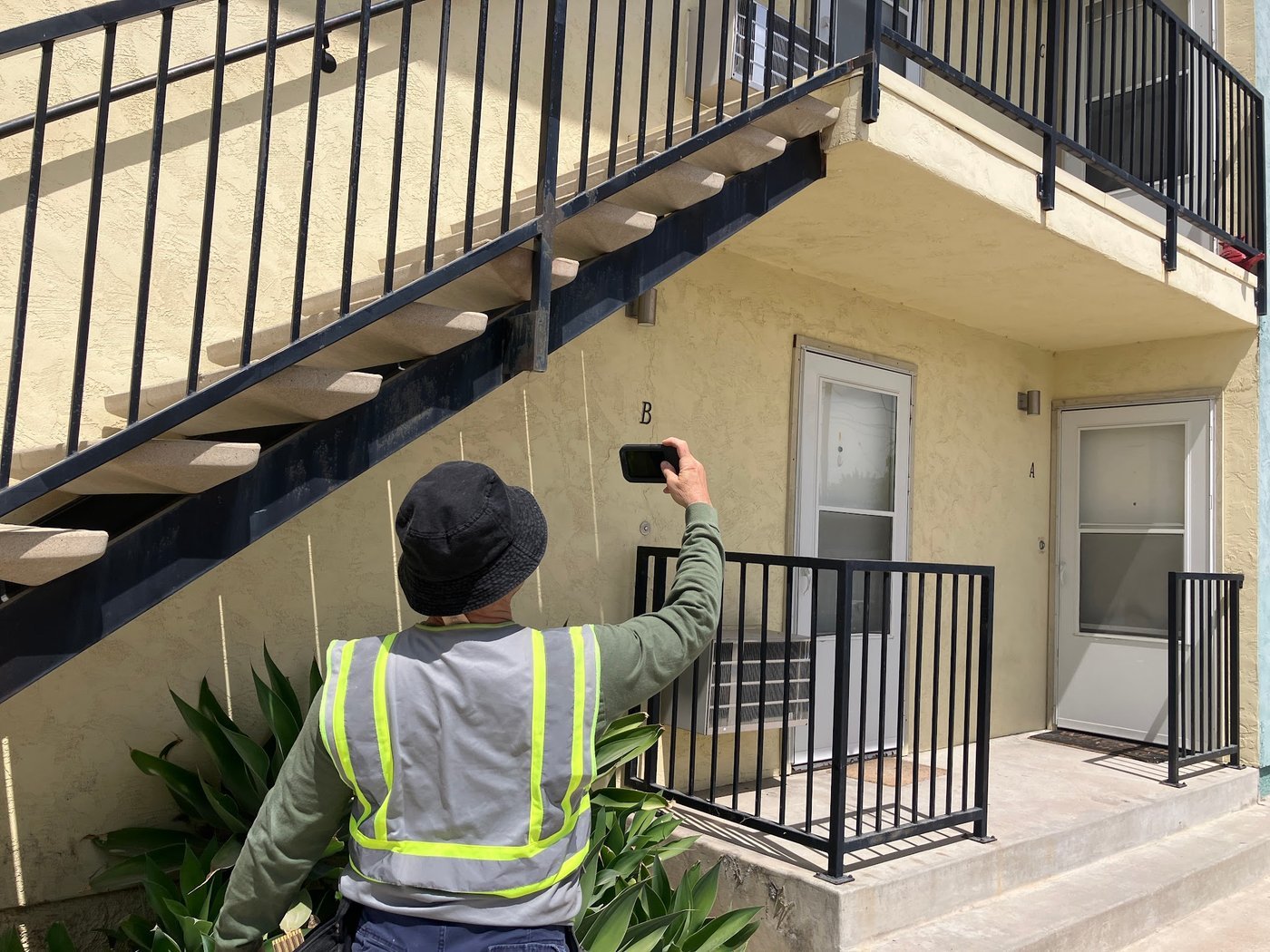 Inspector pointing an infrared camera at a stair soffit