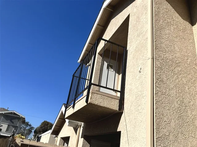 Multifamily condo private balcony with a metal guardrail inspected during a San Diego SB-326 exterior elevated elements inspection.